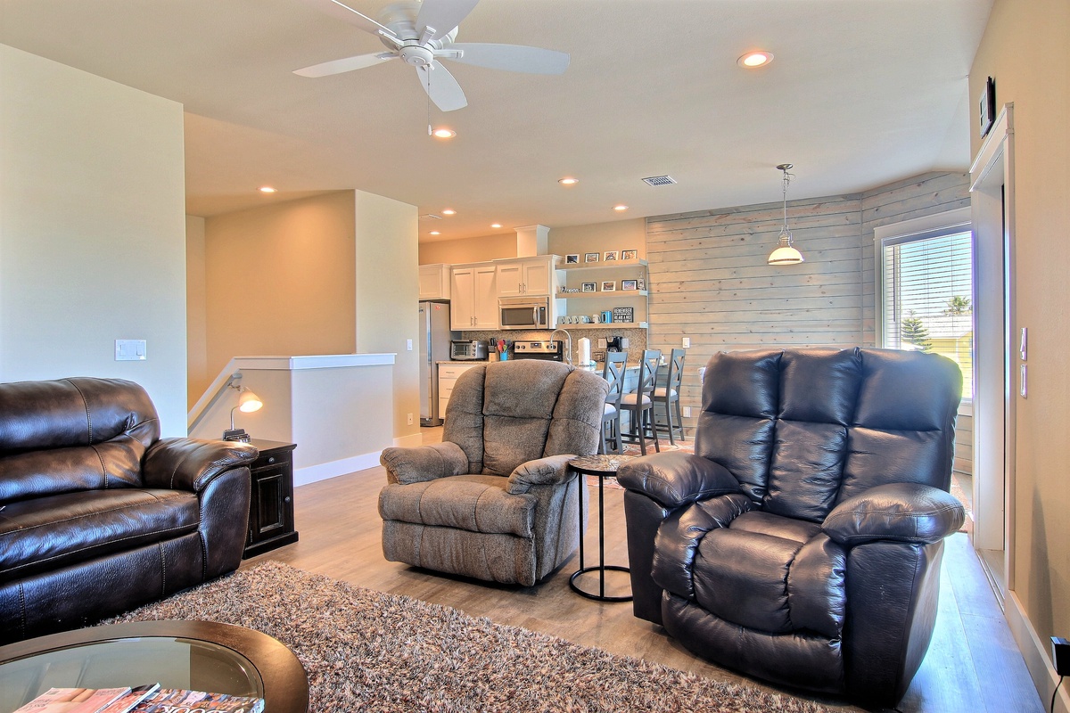 Sink into plush recliners where comfort meets style in your spacious open-concept retreat with modern kitchen.