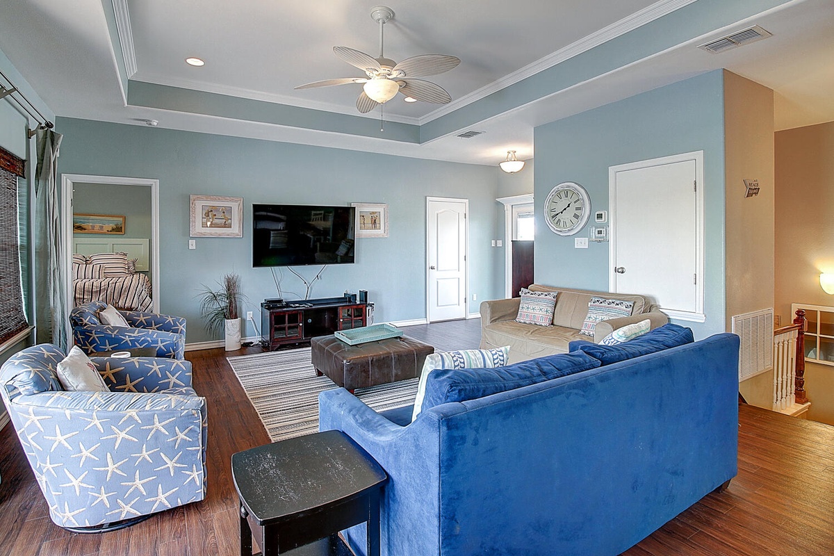 Relax in this spacious living room where coastal blues meet comfort—sink into plush sofas while enjoying your favorite shows.