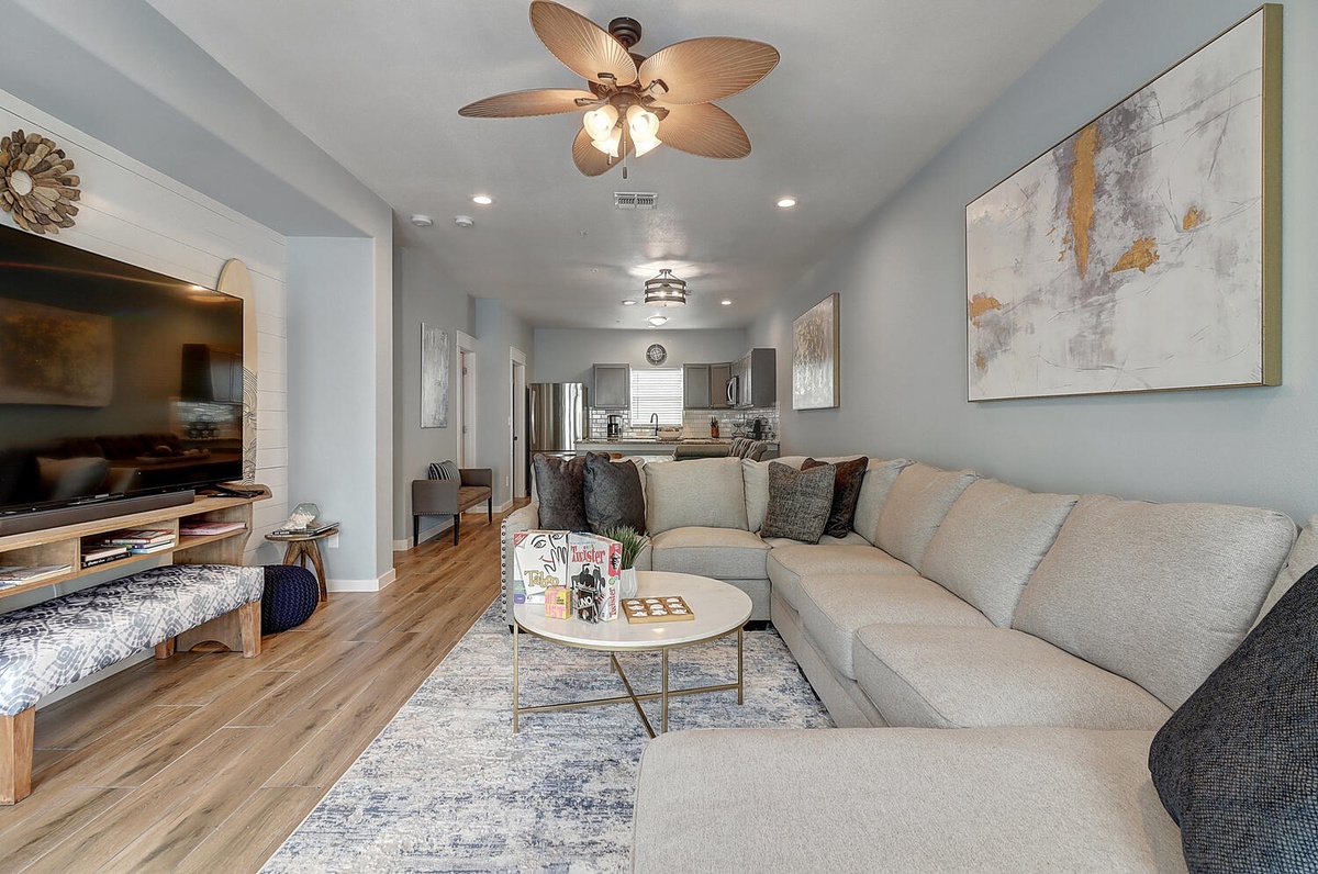 Unwind in your bright, modern living space with plush seating and coastal-inspired artwork creating the perfect atmosphere for relaxation.