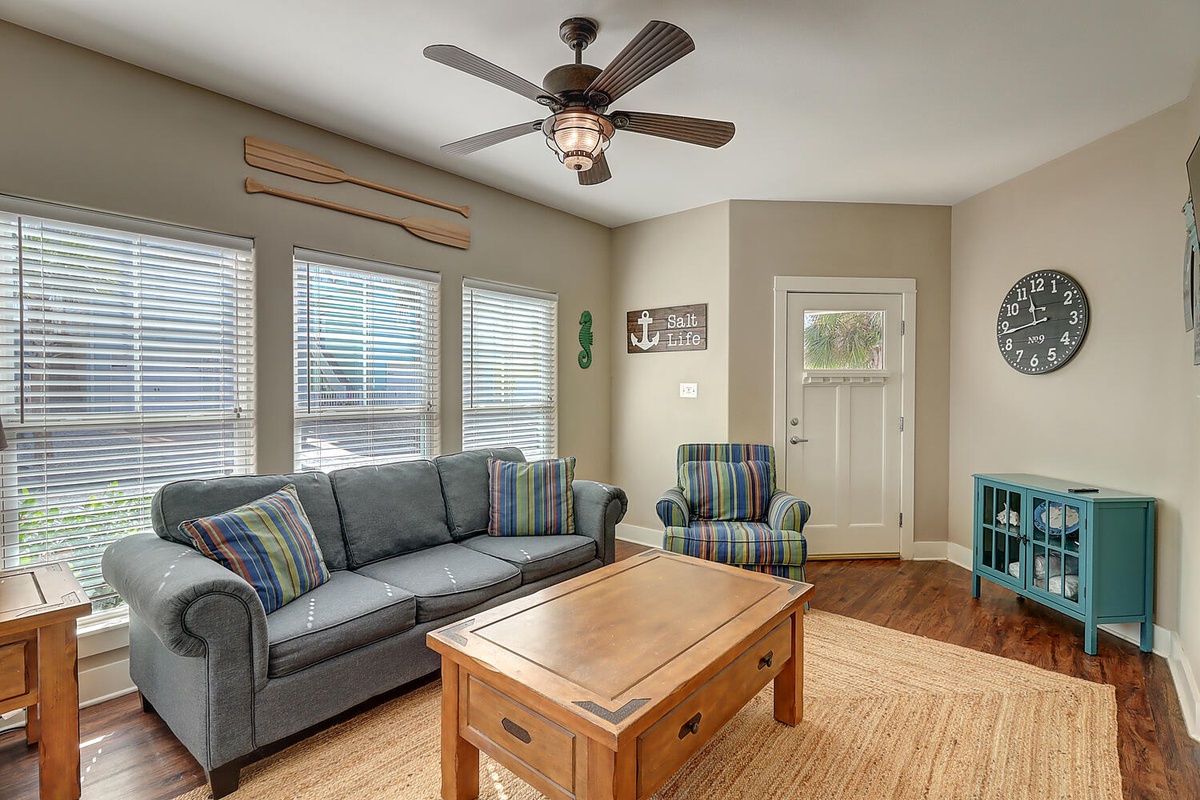 Unwind in your cozy coastal-themed living room with comfortable seating and warm wood details creating the perfect atmosphere for relaxation.