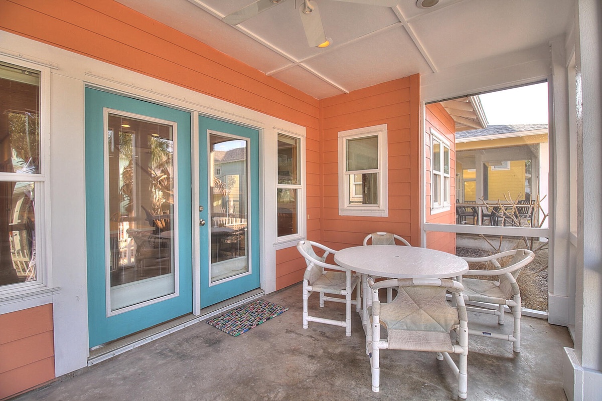 Your covered patio offers the perfect spot for morning coffee or evening meals, with cheerful turquoise doors welcoming you home.