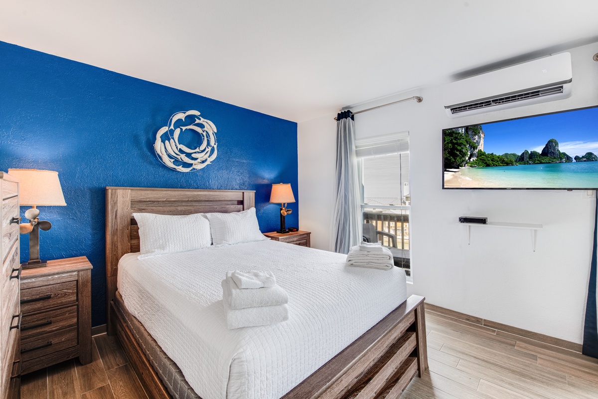 Drift into peaceful sleep in your beautifully appointed bedroom, featuring a plush bed, calming blue accent wall, and tropical views to inspire your island dreams.