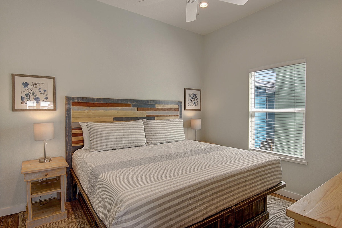 Your peaceful bedroom features a handcrafted reclaimed wood bed, soft striped linens, and warm lighting for restful nights.