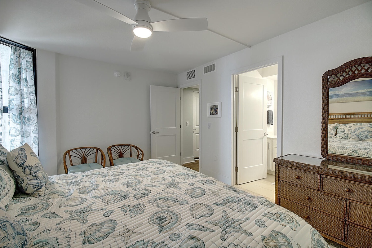 Your coastal-themed bedroom features a comfy bed, wicker furniture, and refreshing ceiling fan for peaceful nights.
