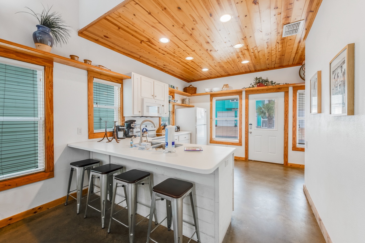 Gather around your bright kitchen island with warm wood details, where morning coffee and evening conversations feel naturally at home.