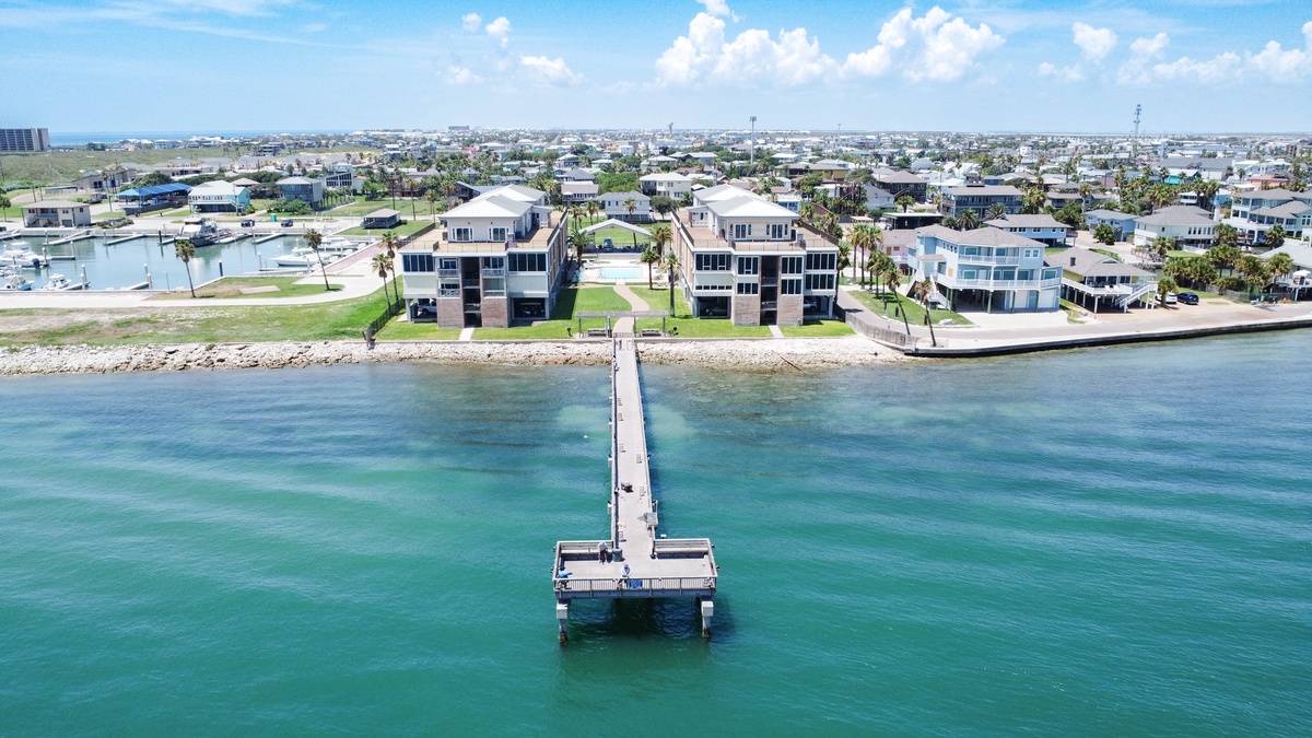 Waterfront properties with private jetty extending into crystal-clear turquoise waters in this coastal community.