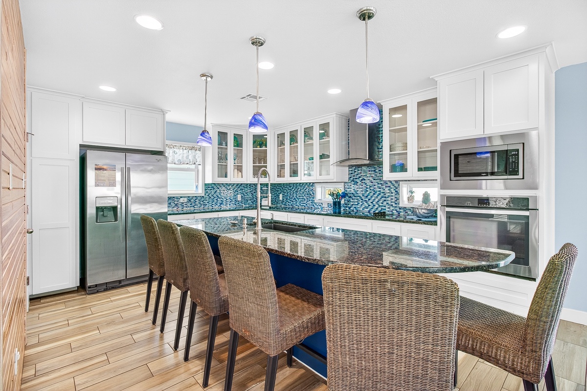 Your gourmet kitchen awaits with stunning blue tile backsplash, granite counters, and a spacious island perfect for morning coffee or evening cocktails.