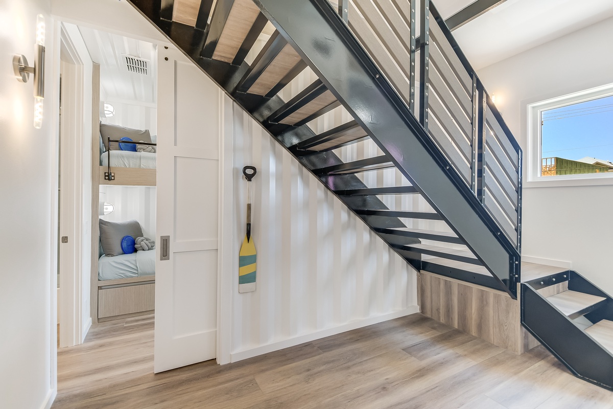 Step into your modern retreat where sleek industrial stairs lead to cozy sleeping nooks, perfectly designed for memorable stays.