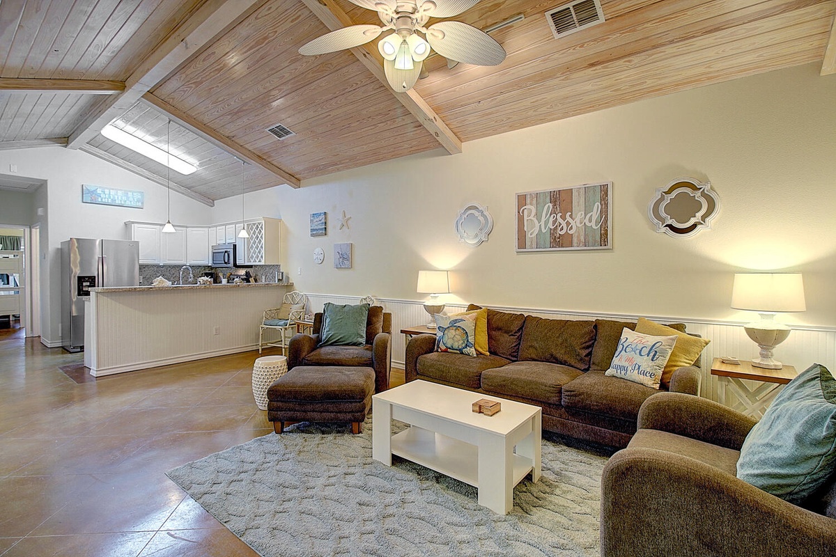 Unwind in your spacious living room featuring vaulted wood ceilings, plush sectional seating, and an open kitchen perfect for gathering.