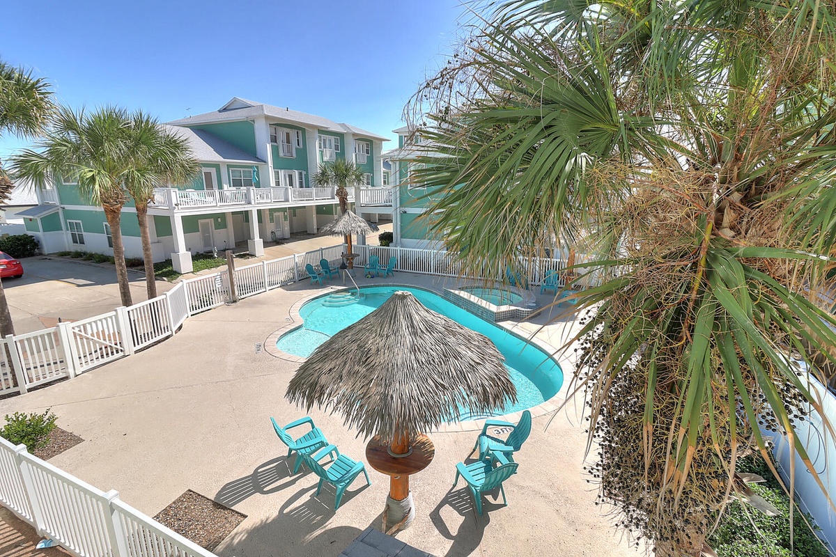 Tropical paradise awaits with your private pool featuring a thatched tiki umbrella and turquoise loungers beneath swaying palms.