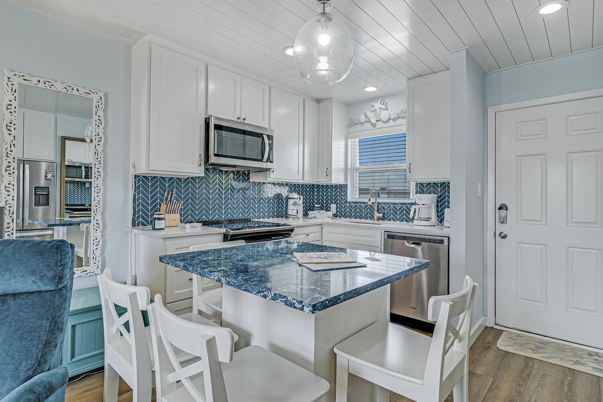 Your fully equipped coastal kitchen features stunning blue granite counters and herringbone backsplash, perfect for preparing seaside meals.