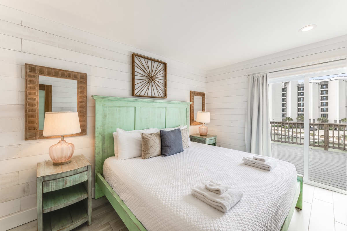 Unwind in your bright coastal retreat with crisp white shiplap, a custom mint-green headboard, and warm wood accents that create the perfect beach house vibe. Thoughtful touches like soft linens and your private balcony make relaxation effortless.