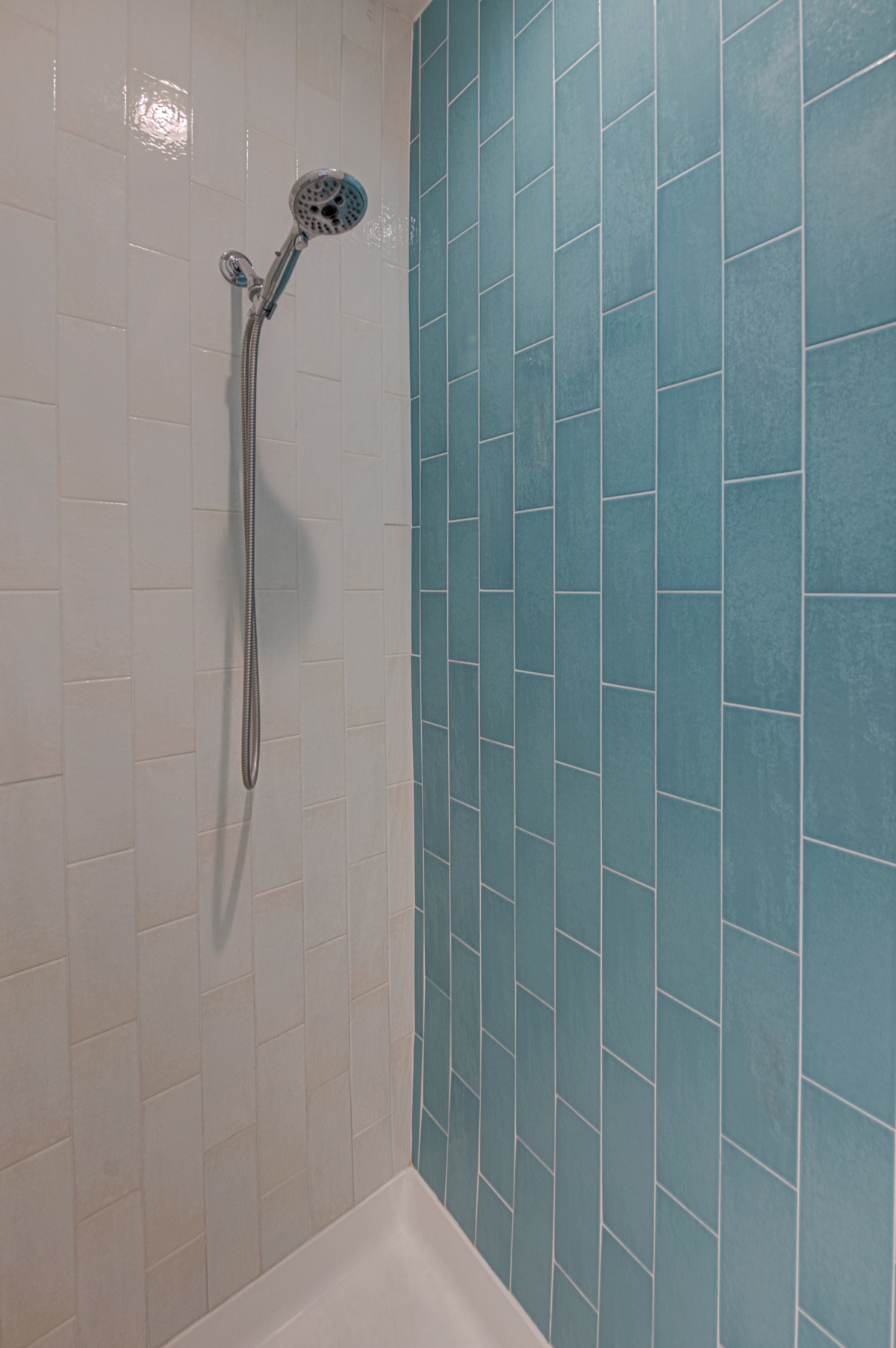 Step into your spa-like shower with stunning teal tiles and rainfall showerhead for rejuvenating mornings.