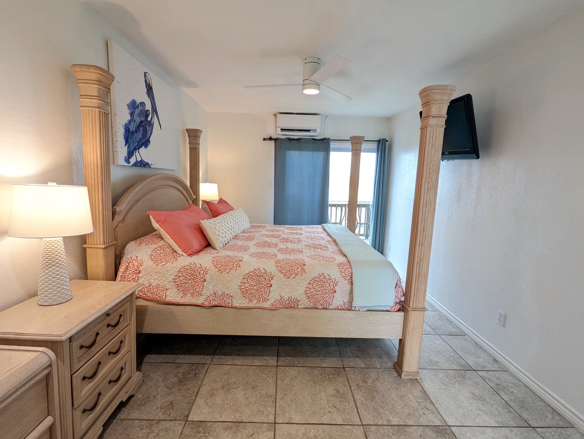 Drift off in your elegant poster bed beneath gentle ceiling fans, with coral accents creating coastal charm.