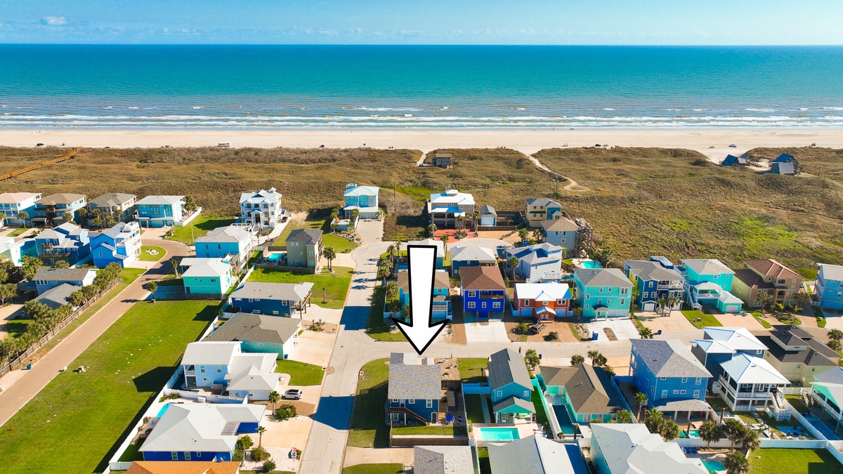Charming beachfront community with colorful coastal homes just steps from pristine sandy shores and rolling ocean waves.