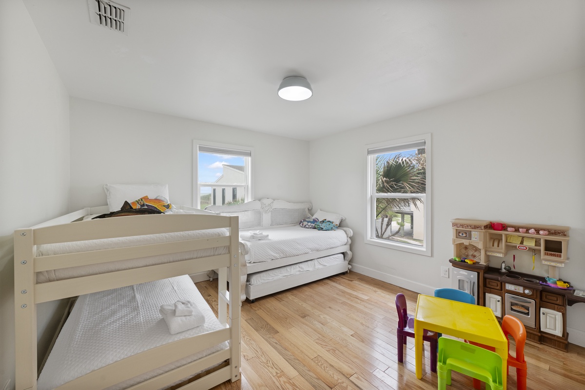 Your kids will love this bright, cheerful room with cozy bunk beds and fun play area by sunny windows.