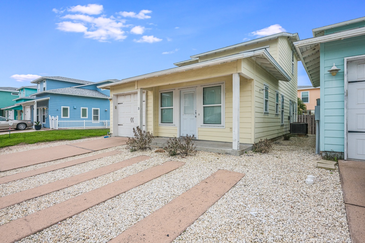 Charming beachside cottage with colorful coastal neighbors creates the perfect seaside retreat atmosphere.