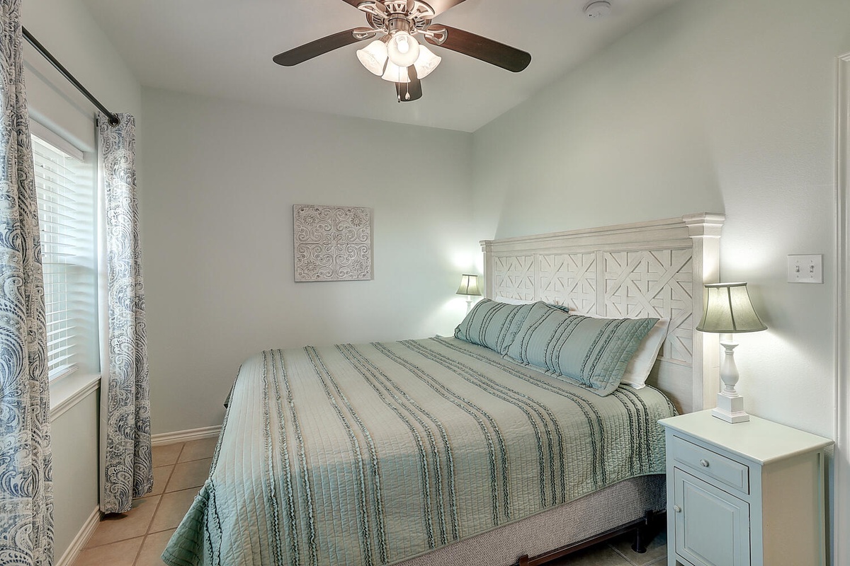 Drift off in your peaceful bedroom with soft coastal colors, gentle ceiling fan breeze, and charming details creating your perfect retreat.