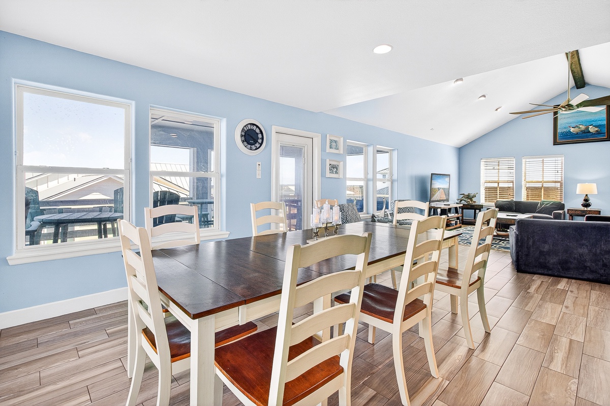 Your open-concept living space flows beautifully with coastal blue walls, where meals become memories around the generous dining table.