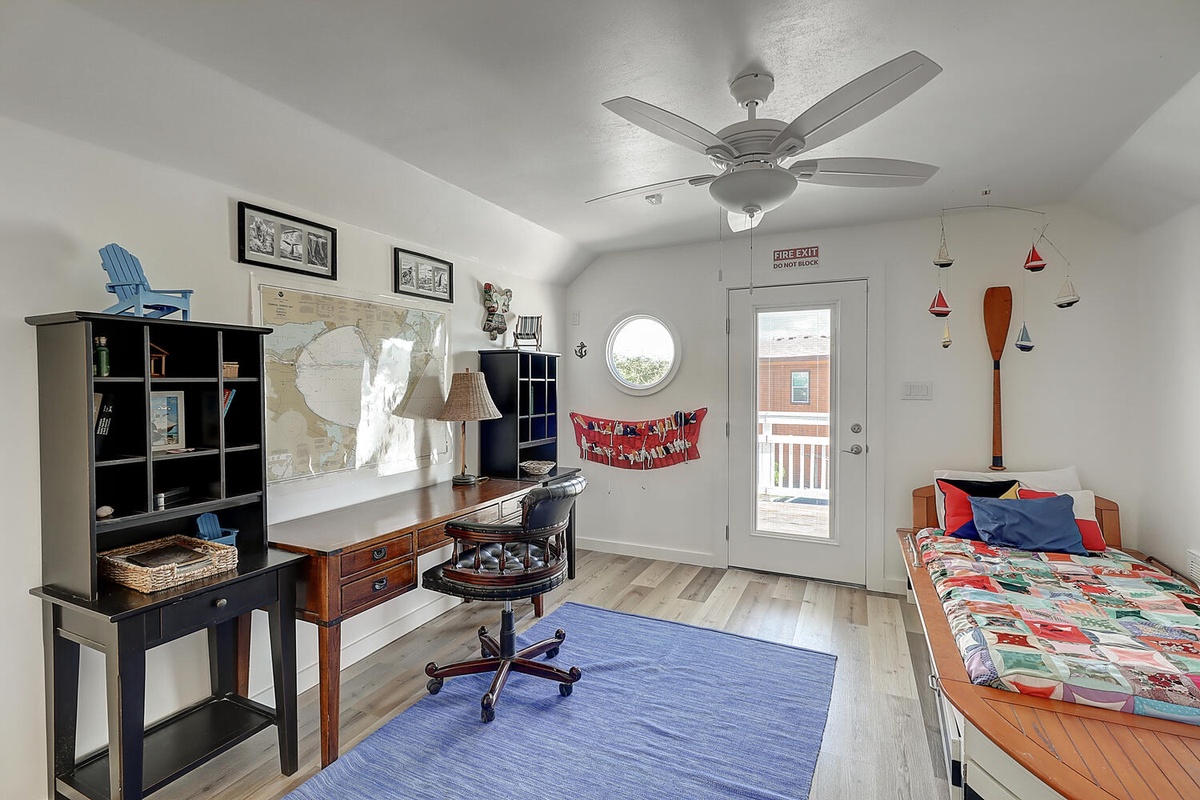 Your nautical-themed room features a comfortable workspace and restful sleeping area with charming maritime decor throughout.
