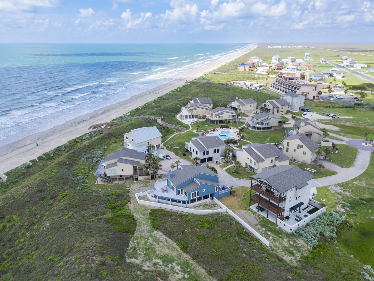 Stunning beachfront community with pristine coastline and resort-style properties nestled between ocean and open landscape.