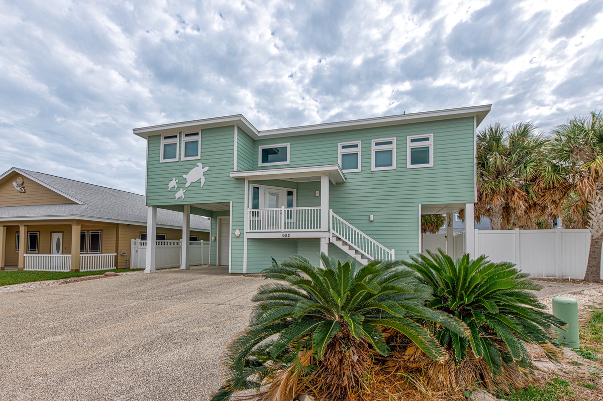 Charming coastal retreat with tropical landscaping and elevated design in a peaceful neighborhood setting.