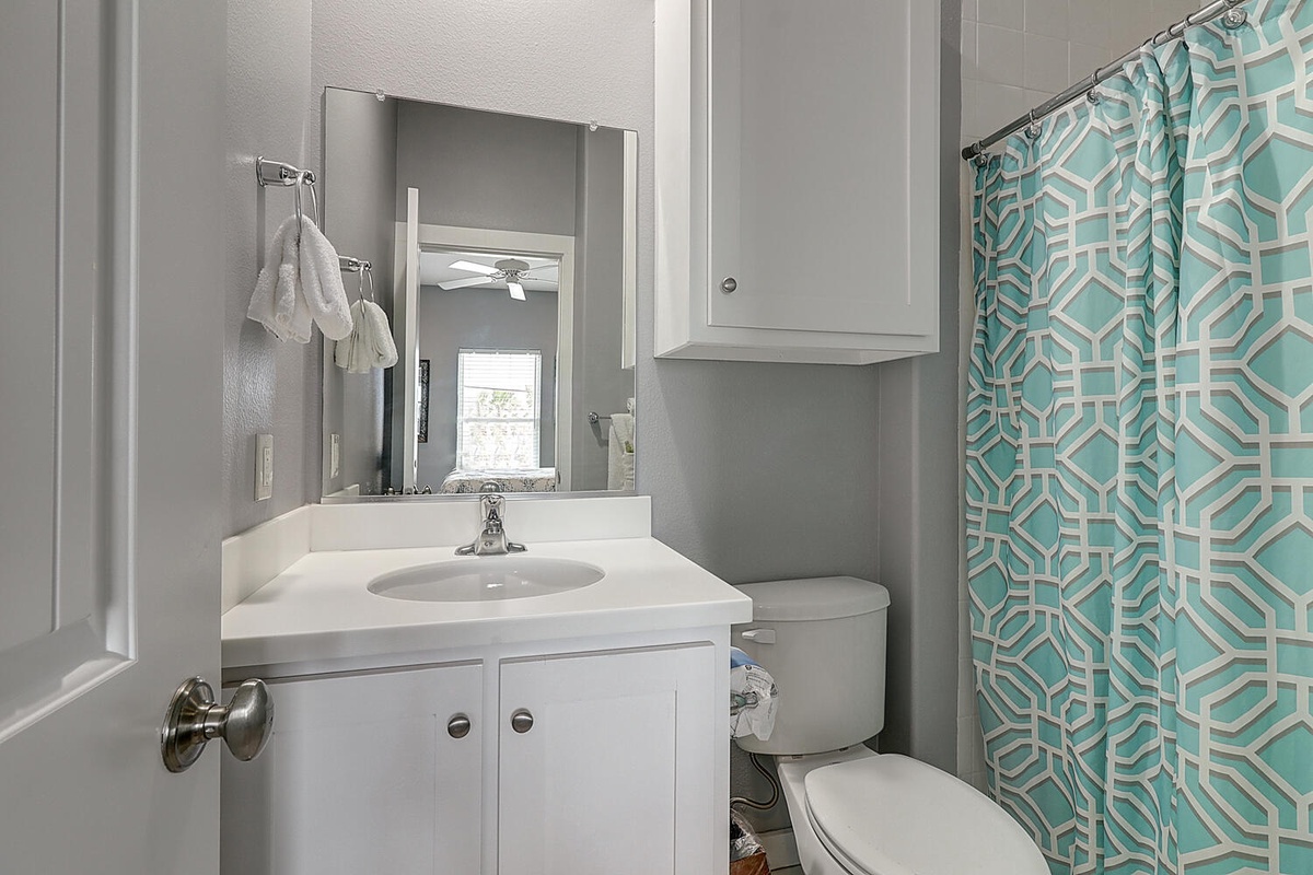 Your private bathroom features modern fixtures and a cheerful geometric shower curtain to brighten your morning routine.