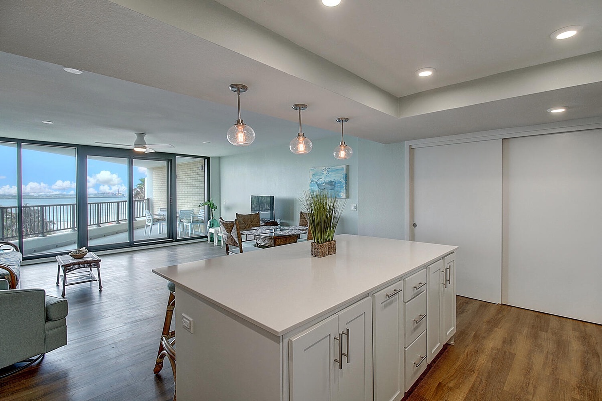 Your stylish kitchen island becomes the heart of gatherings, with pendant lights creating ambiance while city views stretch beyond floor-to-ceiling windows.