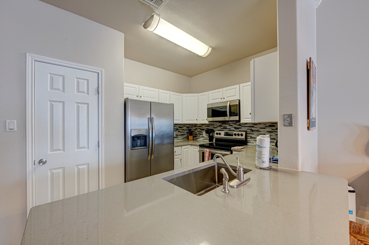 Your fully-equipped kitchen awaits with gleaming countertops, stainless steel appliances, and everything you need to create memorable meals during your stay.