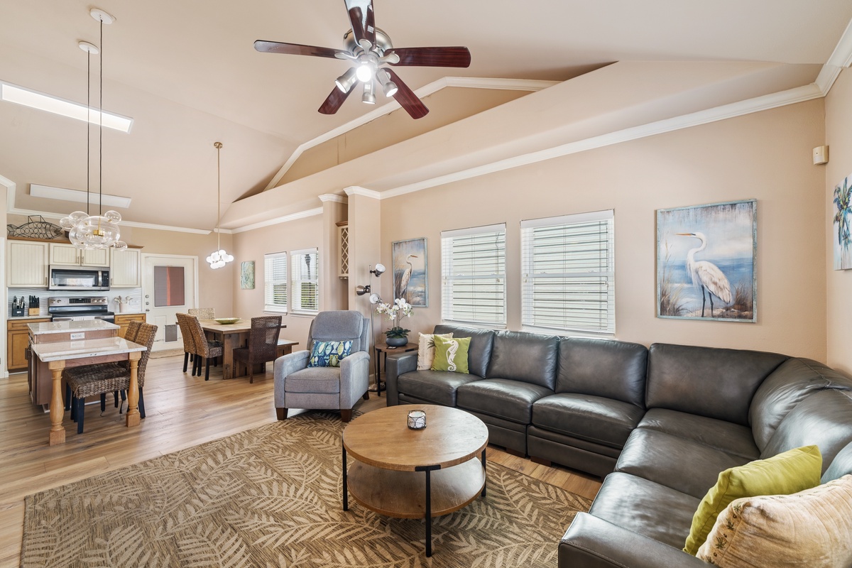 Gather in the inviting living area with plush seating, fresh coastal accents, and an open layout designed for relaxing after a day at the beach.