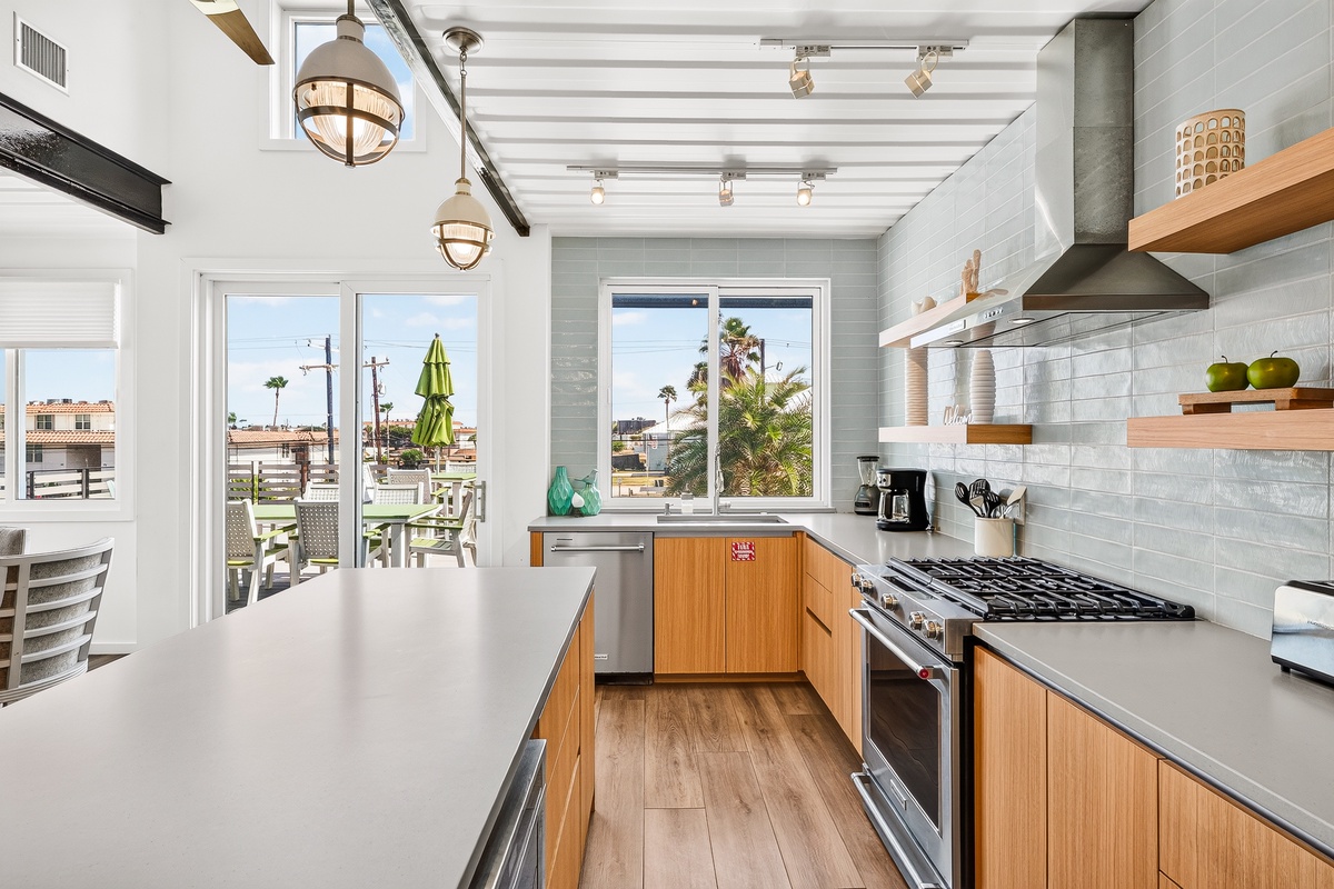 You'll love cooking in this bright, modern kitchen with sleek appliances and warm wood accents. Natural light floods the space, and palm-fringed views remind you you're somewhere special.