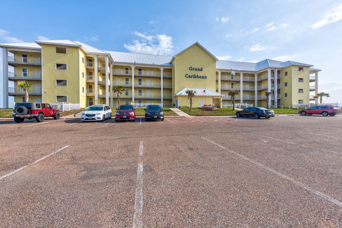 Grand Caribbean resort building with ample parking and palm trees creating a welcoming coastal arrival experience.