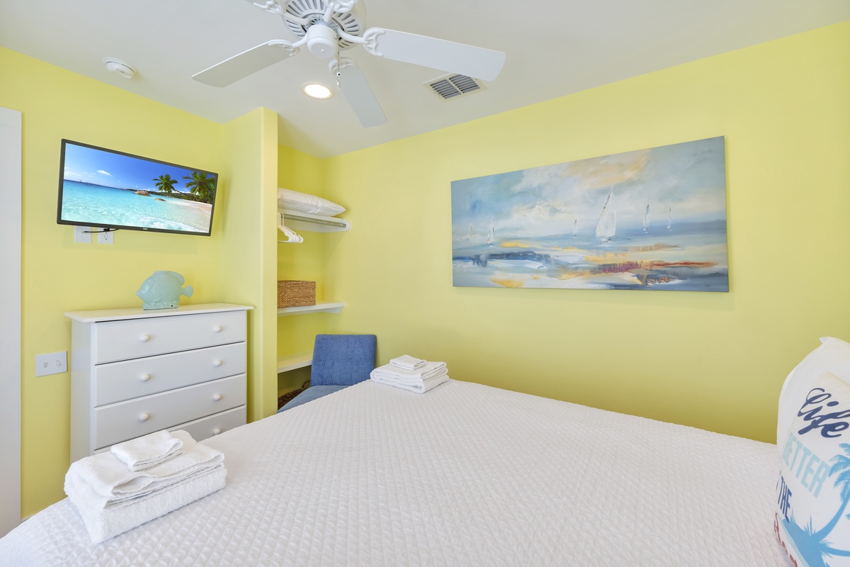 Drift off to sleep in this cheerful bedroom with coastal artwork adorning sunny yellow walls and fresh towels awaiting your arrival.