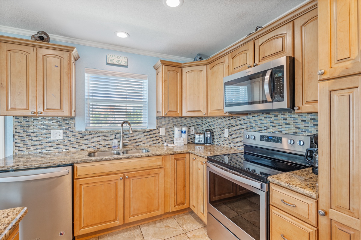 Your fully equipped kitchen features warm wood cabinets, granite countertops, and everything needed to prepare memorable meals during your stay.