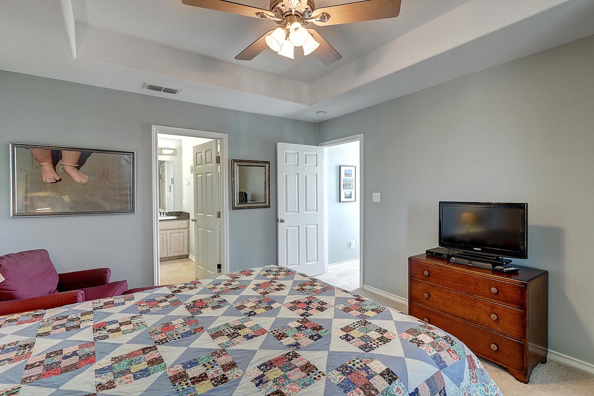 Unwind in your spacious bedroom featuring a beautiful handmade quilt, flat-screen TV, and convenient access to your private bathroom.