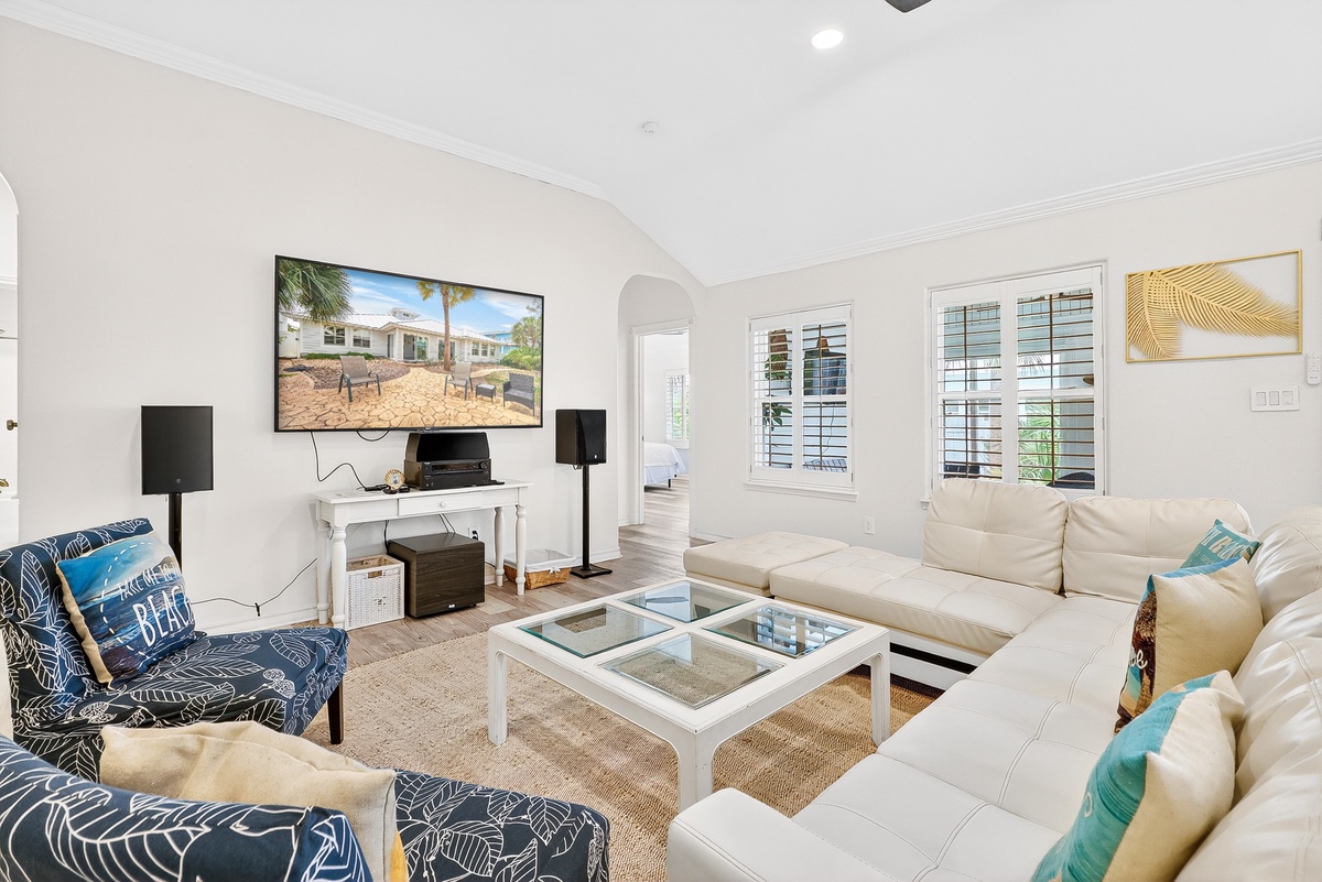Sink into plush sofas with turquoise accents while enjoying your favorite shows on the large TV in this bright, airy living space.