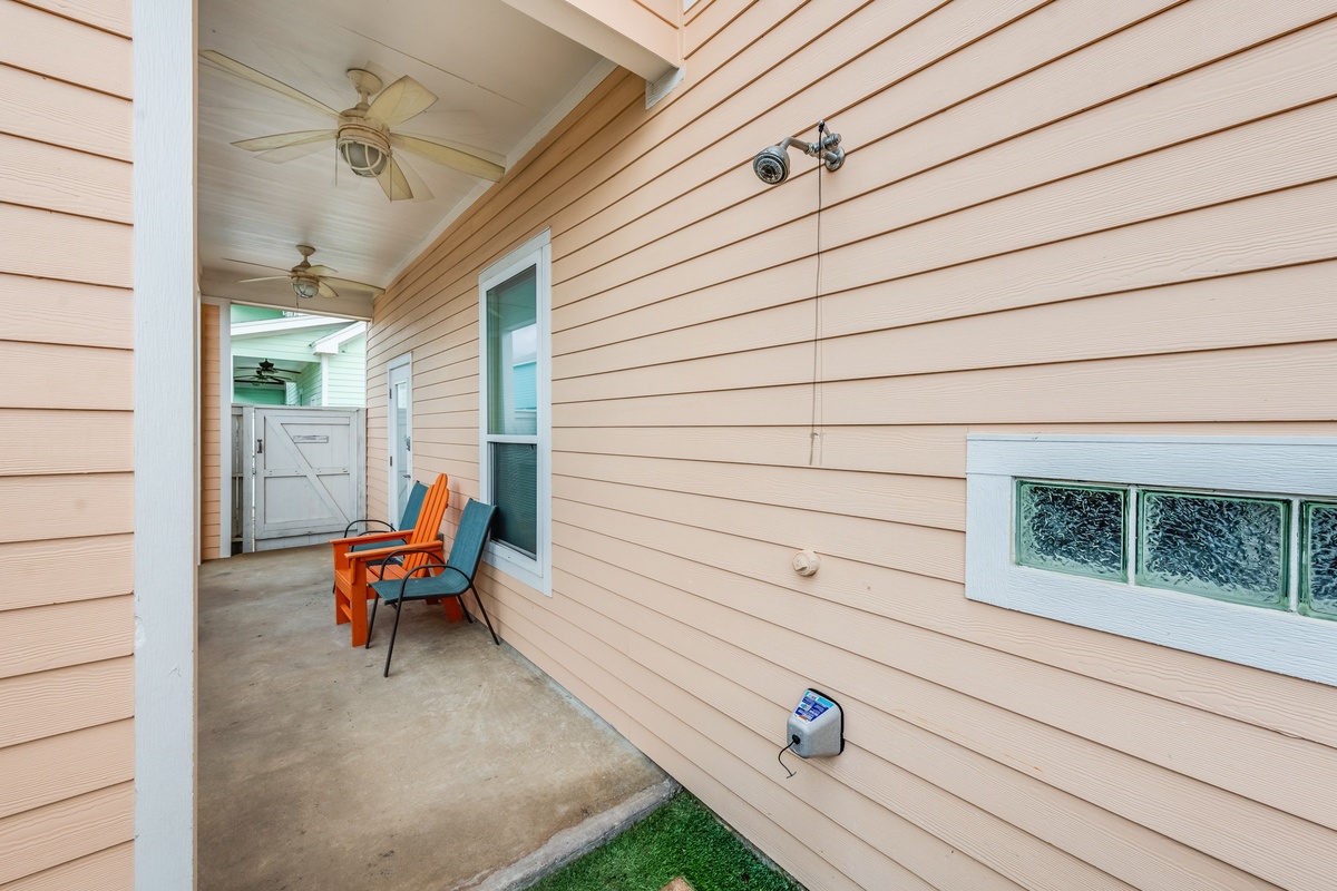 Step onto your covered porch and settle into vibrant orange chairs where ceiling fans keep you cool during warm evenings.