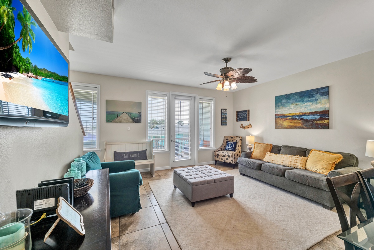Sink into plush seating while watching your favorite shows on the large TV, surrounded by coastal-inspired decor and natural light.