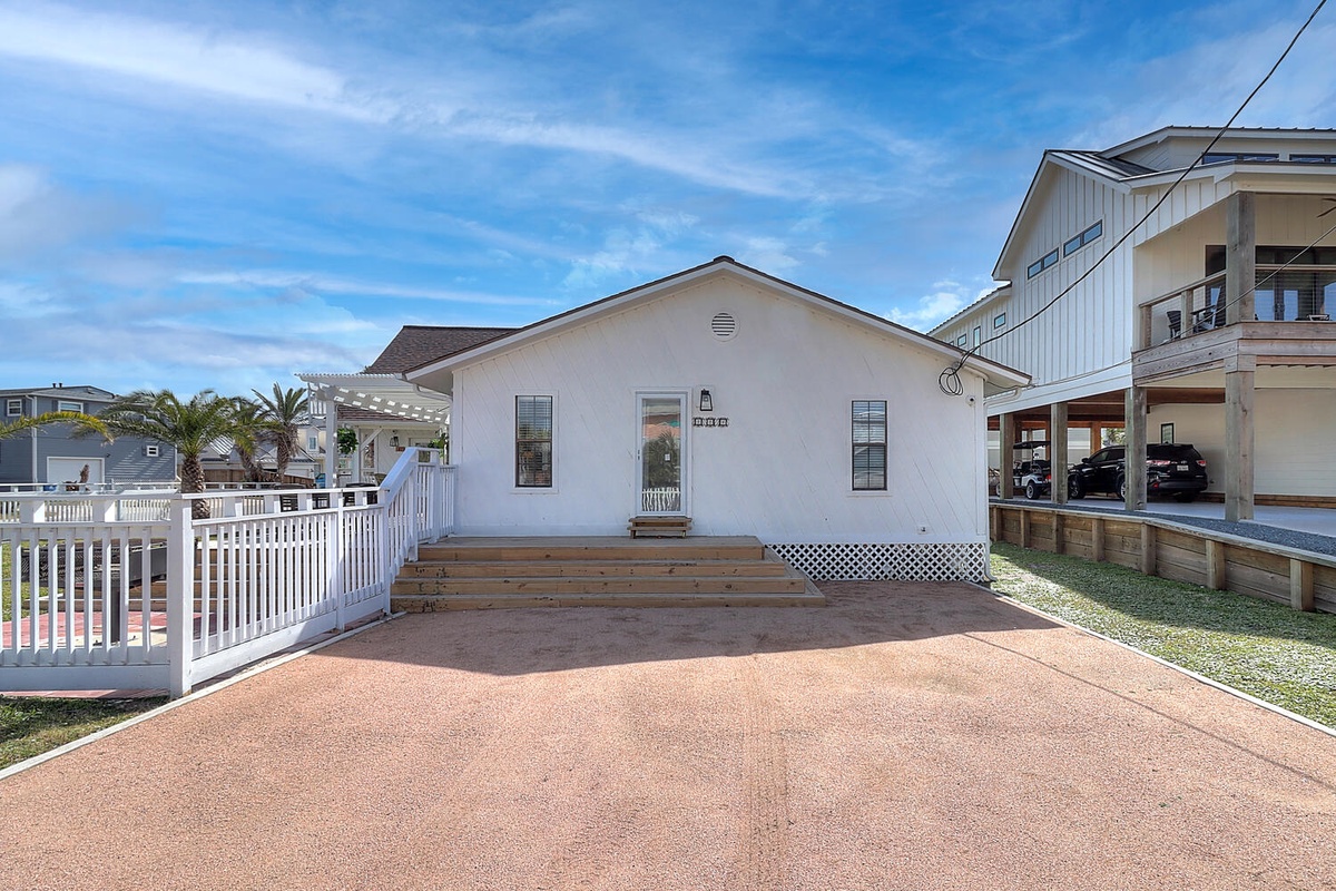Charming white coastal cottage with covered parking and easy beach access in a quiet residential neighborhood.