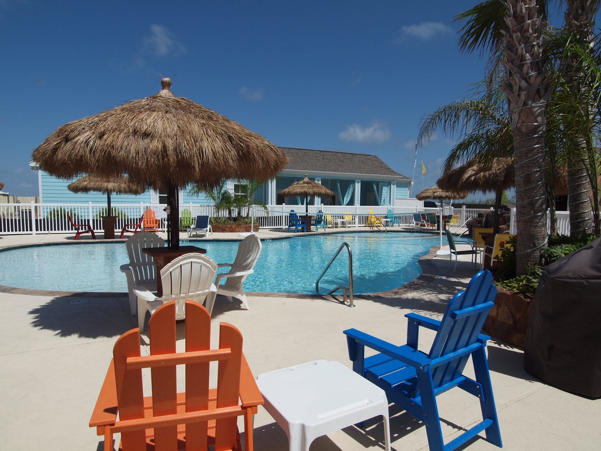Dive into your tropical paradise with vibrant poolside seating, thatched umbrellas, and swaying palms creating the perfect backdrop for relaxation.