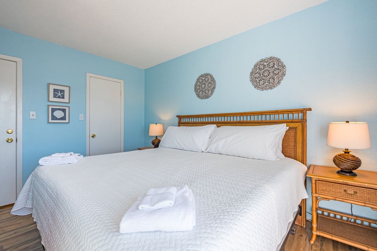Drift off to sleep in this serene coastal bedroom where soft blue walls and crisp linens create your peaceful seaside retreat.