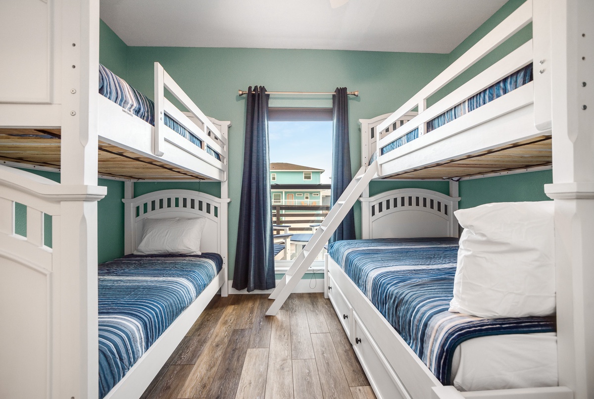 Your coastal bunk room offers comfortable sleeping for four with nautical blue linens and serene sea-green walls.