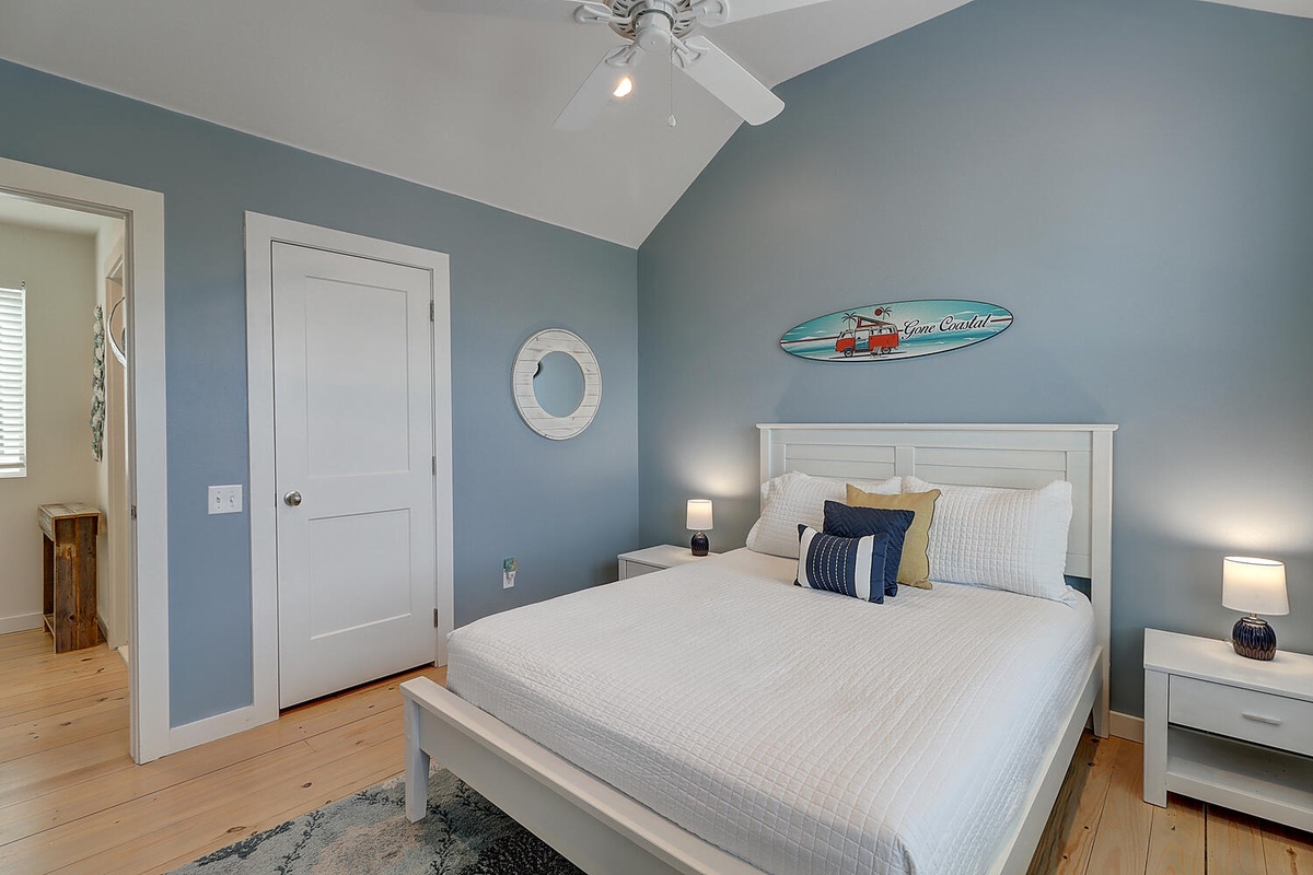 Drift off in this coastal-inspired bedroom with soft blue walls and surfboard art. Your white linens promise comfort after days exploring.