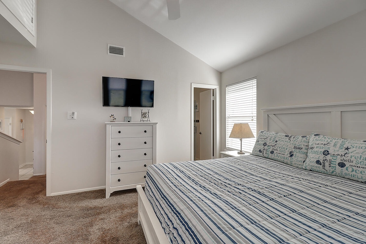 Drift into peaceful sleep in your bright bedroom with coastal bedding, wall-mounted TV, and ample storage for all belongings.