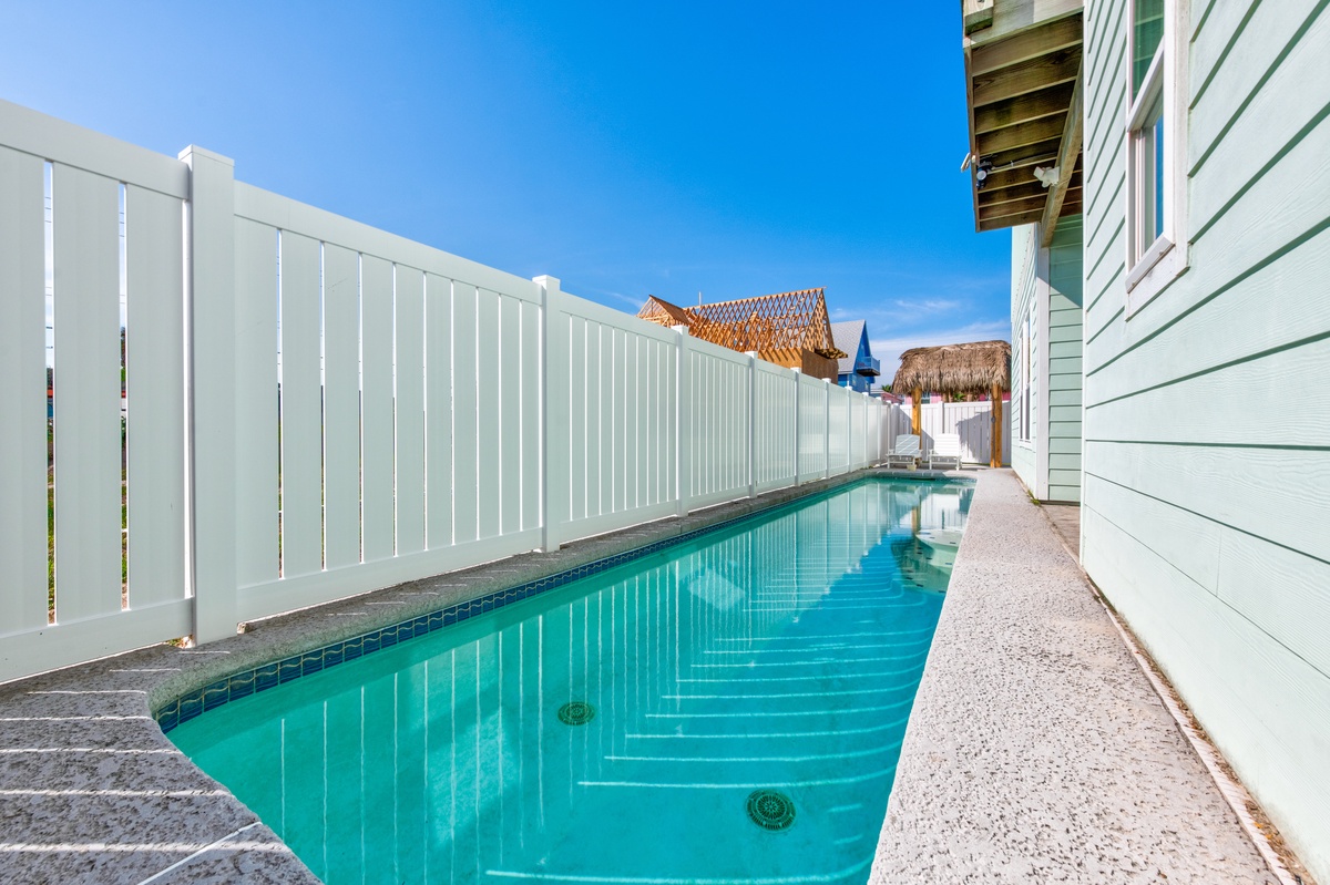 Step into your private poolside sanctuary where turquoise waters invite you for a refreshing swim under endless blue skies.