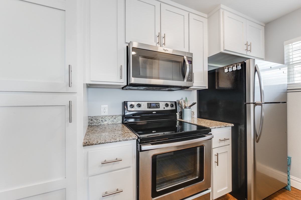 Your fully-equipped kitchen features granite countertops, stainless steel appliances, and crisp white cabinetry for effortless meal preparation.