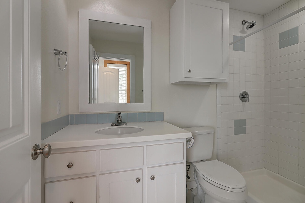 Your private bathroom features a clean vanity, mirror, and tiled shower for comfortable daily routines.