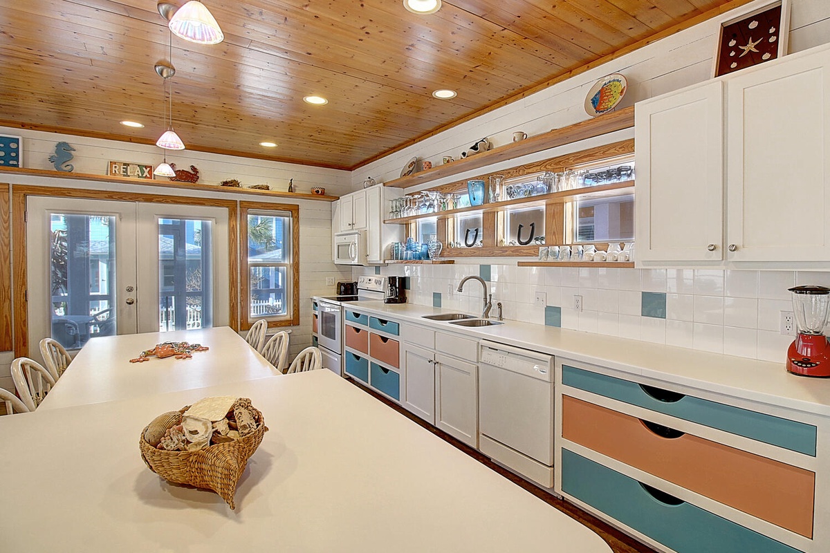 Your spacious kitchen invites culinary adventures with colorful accents, gleaming countertops, and warm wood ceilings creating the perfect gathering spot.