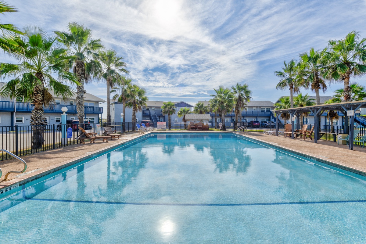 Dive into crystal-clear waters surrounded by swaying palms at this tropical paradise pool, where sunny days and relaxation await you.