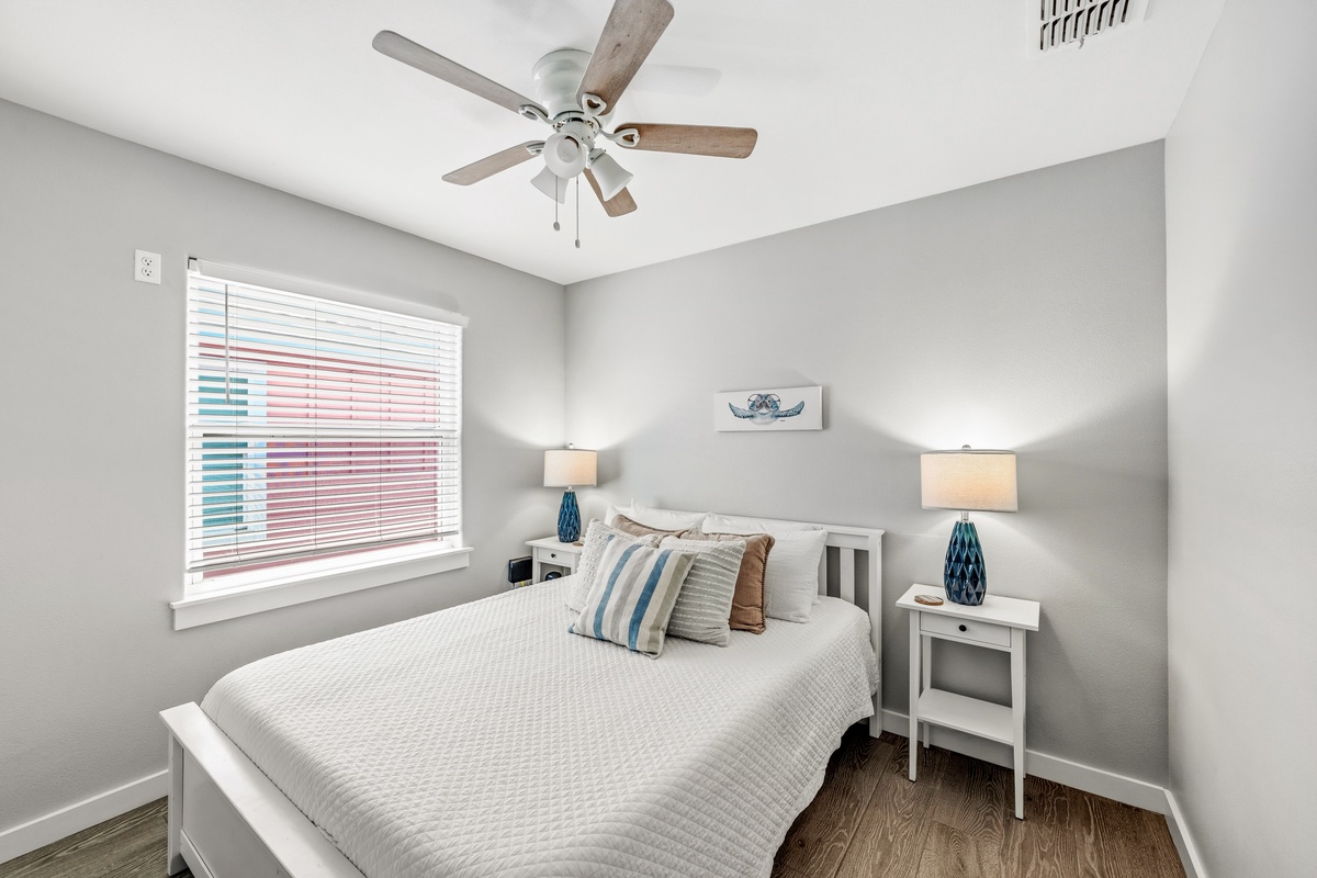 Step into your serene bedroom retreat with crisp coastal style, a cozy queen bed, and soft lighting to help you unwind after a day of adventure.